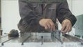 Worker with a scraper chamfering removing burrs on metal object for manufacturing industrial CNC machines Royalty Free Stock Photo