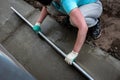 Worker screeding outdoor cement floor with screed Royalty Free Stock Photo