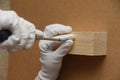 A worker screws a screw into a wooden block with a screwdriver. Royalty Free Stock Photo