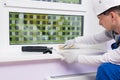 A worker seals the cracks of a plastic window