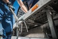 Worker Securing Car on Towing Truck with Tie Down Belts Royalty Free Stock Photo