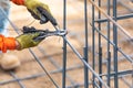 Worker Securing Steel Rebar Framing With Wire Plier Cutter Tool