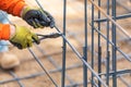 Worker Securing Steel Rebar Framing With Wire Plier Cutter Tool