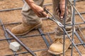 Worker Securing Steel Rebar Framing With Wire Plier Cutter Tool