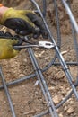 Worker Securing Steel Rebar Framing With Wire Plier Cutter Tool