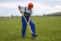 Worker with Shovel on a Green Lawn