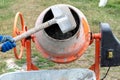 A worker shovels sand into a concrete mixer, preparing cement mortar Royalty Free Stock Photo