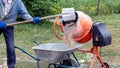 A worker shovels sand into a concrete mixer, preparing cement mortar Royalty Free Stock Photo