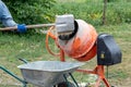 A worker shovels sand into a concrete mixer, preparing cement mortar Royalty Free Stock Photo
