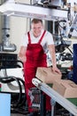 Worker showing thumbs up sign next to conveyor belt Royalty Free Stock Photo