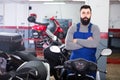 Worker shows a variety of motorcycle Royalty Free Stock Photo