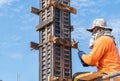 A worker sits on a scaffold, tightem screw clamp support framework of pole Royalty Free Stock Photo