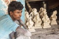 A worker sitting in front of Ganesh idols