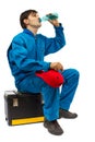 Worker sitting on the toolbox drinking water