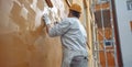 A Worker Skillfully Paints the Wall in Rich Brown with a Steady Hand and Roller Royalty Free Stock Photo