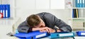 Worker sleep on documents folders workplace, overwork problem concept