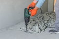 Worker smashes concrete floor with electric hammer drill Royalty Free Stock Photo