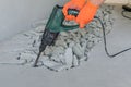 Worker smashes concrete floor with electric hammer drill Royalty Free Stock Photo