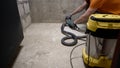 A worker smoothest the floor with an angle grinder. Grinding a concrete floor with a grinding machine before repair. A