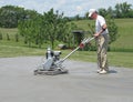 Worker smoothing concrete with a power trowel Royalty Free Stock Photo