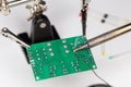 Worker is soldering a resistor