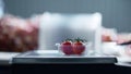 Worker sorting cherry tomatoes packing process cutting parts on scales closeup