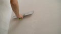 Worker spackles the walls with a spatula. Spatula with putty in hand. Worker puts of plaster on wall. Royalty Free Stock Photo