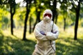 A worker in special clothing for working with pesticides in an outdoor park. Pest control, insect disinfestation