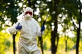 A worker in special clothing for working with pesticides in an outdoor park. Pest control, insect disinfestation