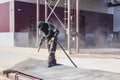 A worker in a special suit is sandblasting metal at an industrial site