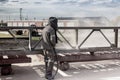 A worker in a special suit is sandblasting metal at an industrial site