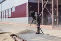 A worker in a special suit is sandblasting metal at an industrial site