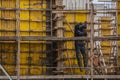 A man jumps down the stairs and at the same time talking on the phone in a dirty working uniform without insurance. Construction