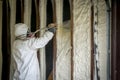 Worker spraying closed cell spray foam insulation on a home wall Royalty Free Stock Photo