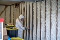 Worker spraying closed cell spray foam insulation on a home wall