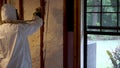 Worker spraying closed cell spray foam insulation on a home wall