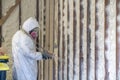 Worker spraying closed cell spray foam insulation on a home wall Royalty Free Stock Photo