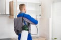 Worker Spraying Insecticide On Shelf