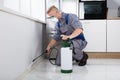 Worker Spraying Pesticide On Wall Royalty Free Stock Photo