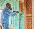 Worker spraying polyurethane foam for insulating wooden frame house. Royalty Free Stock Photo