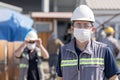 The worker staff, engineer protects himself from covid-19 coronavirus with a protective mask in the construction site.