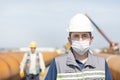 The worker staff, engineer protects himself from covid-19 coronavirus with a protective mask in the construction site. Royalty Free Stock Photo