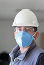 The worker staff, engineer protects himself from covid-19 coronavirus with a protective mask at the office.