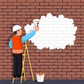 Worker standing on a ladder paints a wall