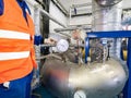 Worker stands by a chrome pipe with pressure and temperature control Royalty Free Stock Photo