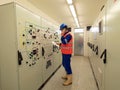 Worker stay in large control room. Power Plant Control Panels with schema. Engineer standing in front of the control panel Royalty Free Stock Photo