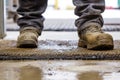 worker stepping on a greasy doormat