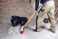 Worker sweeping rubble and dust with red broom