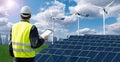 Worker with tablet computer on a background of wind turbines and solar panels Royalty Free Stock Photo