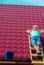 A worker takes a sun bath on the roof of the house during Royalty Free Stock Photo